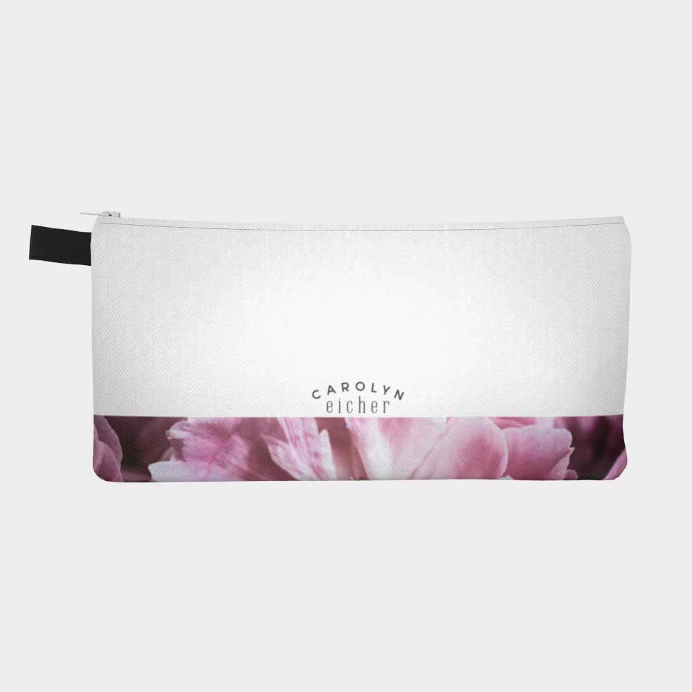 Plain back of zippered pouch with magenta floral peony band and logo.