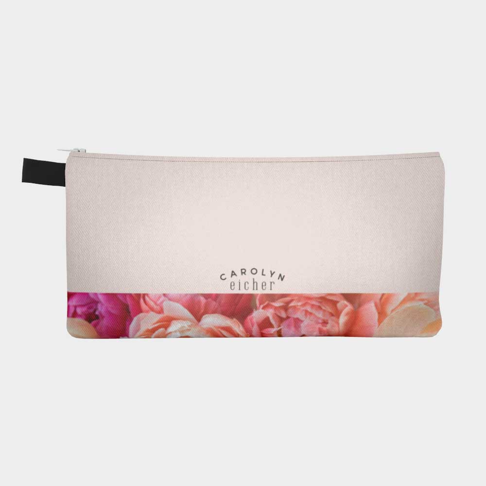 Plain back of zippered pouch with pink floral peony band and logo.