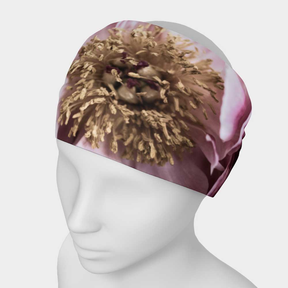 Designer headband of a magenta peony flower shown on white mannequin with yellow center of flower highlighted in this image.