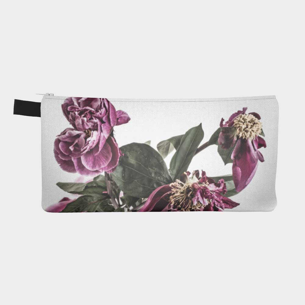 Close-up of zippered pouch with drying peony flowers in soft magenta color.